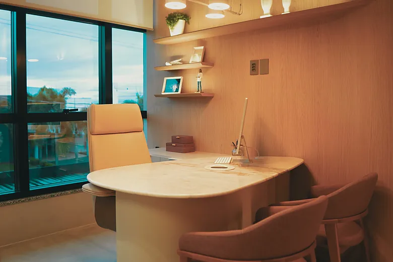 A sala de avaliação da Avitta, com a mesa de mármore e as cadeiras das pacientes